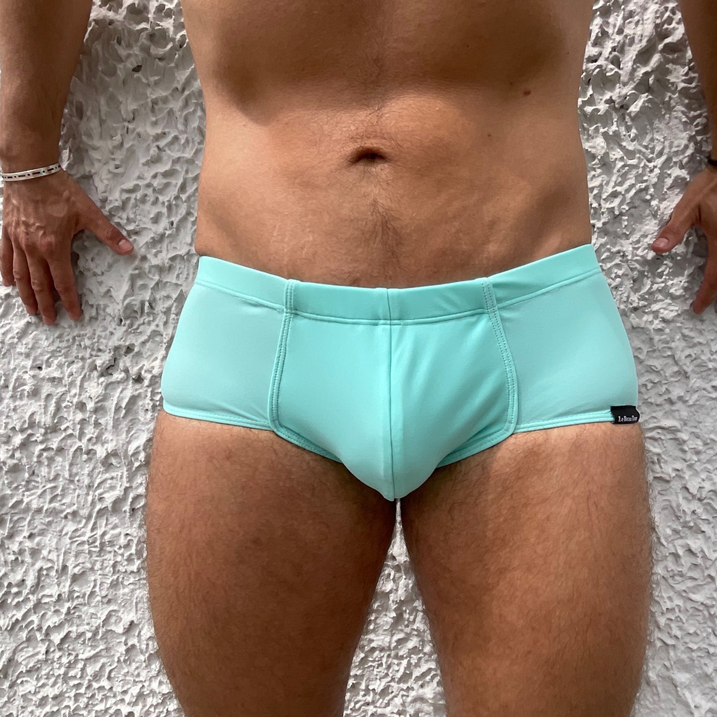 Gros plan sur le boxer shorty de bain turquoise pour homme de la marque Lyonnaise de maillots et de sous-vêtements fabriqués au Portugal.