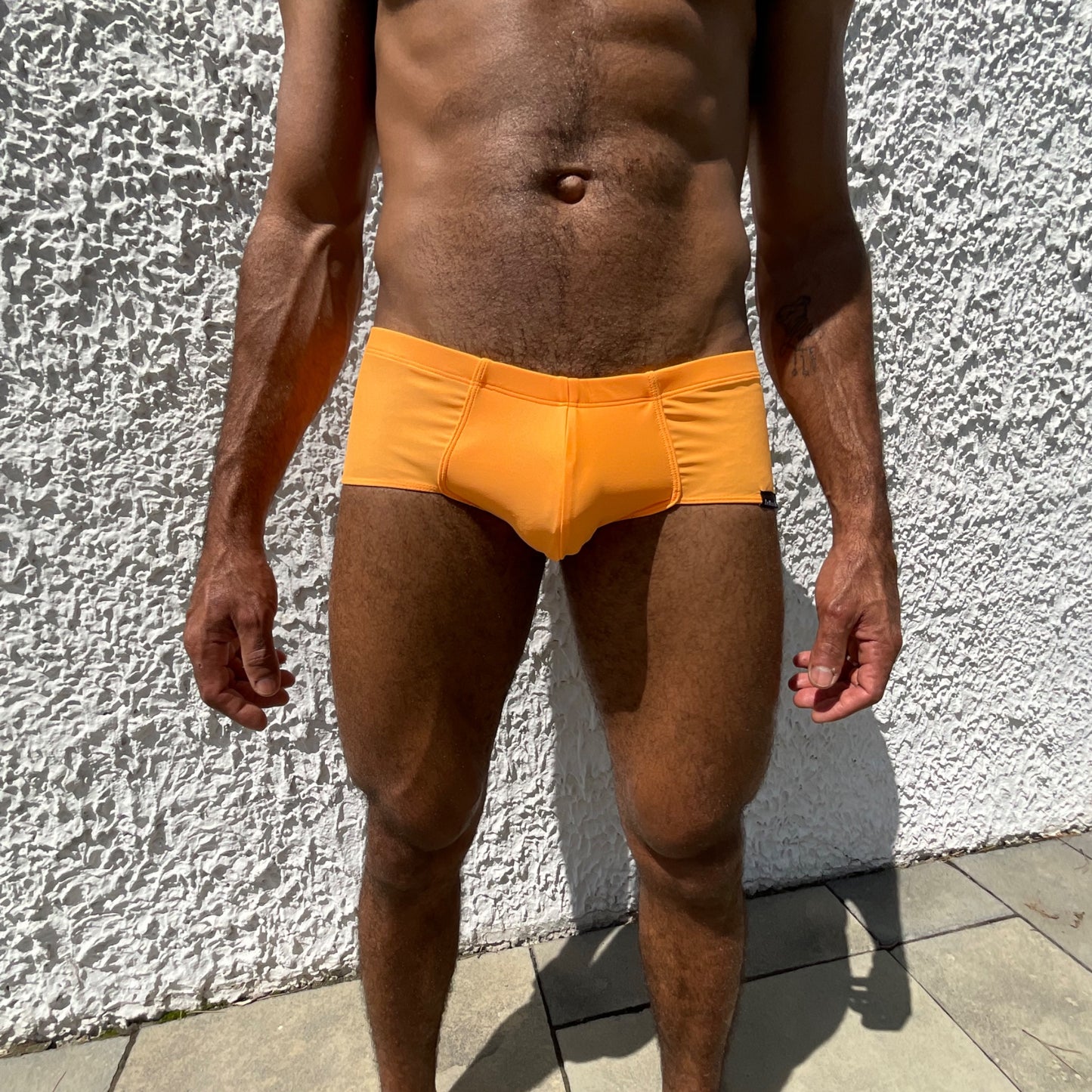 Vue de face en gros plan sur le boxer shorty orange de la marque de maillots de bain française Le Beau Tom, entreprise Lyonnaise, fabrication Portugal
