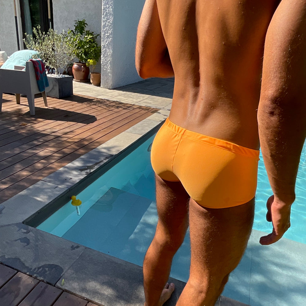 Vue de dos du shorty de bain orange de la marque Le Beau Tom, créateur Lyonnais de maillots de bain et de sous-vêtements pour homme.