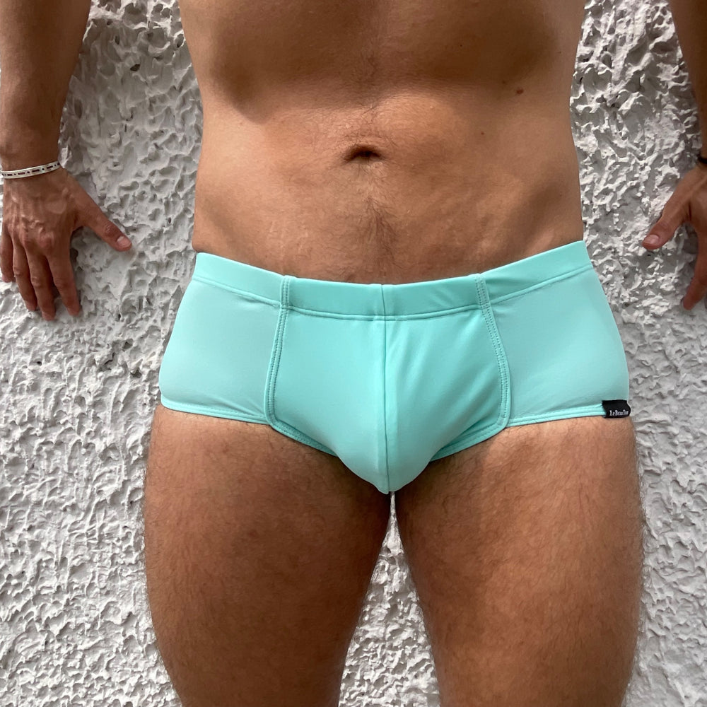 
                  
                    Gros plan sur le boxer shorty de bain turquoise pour homme de la marque Lyonnaise de maillots et de sous-vêtements fabriqués au Portugal.
                  
                