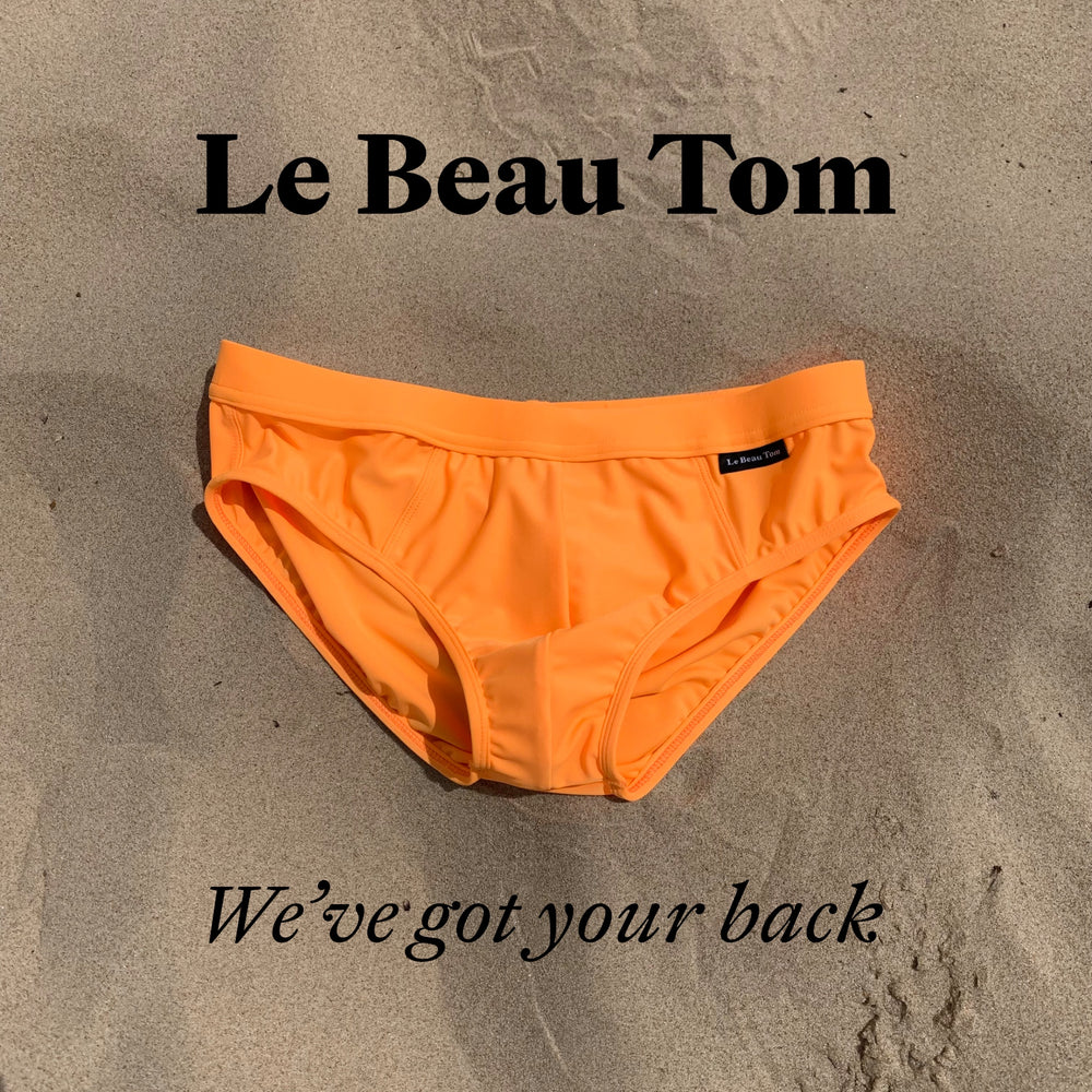 
                  
                    Vue simple du maillot de bain orange pour homme de la marque Le Beau Tom. Posé simplement sur le sable, on remarque la couleur vibrante de cette pièce proposée par la marque Lyonnaise de sous-vêtements et de maillots de bain. La plupart des pièces sont fabriqués au Portugal.
                  
                