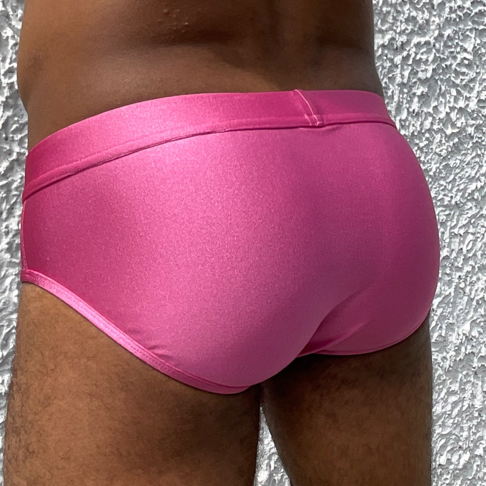 Gros plan sur le derrière d'un homme sexy mis en valeur par le maillot de bain fuschia de la marque Française Le Beau Tom. Fabrication Portugal.