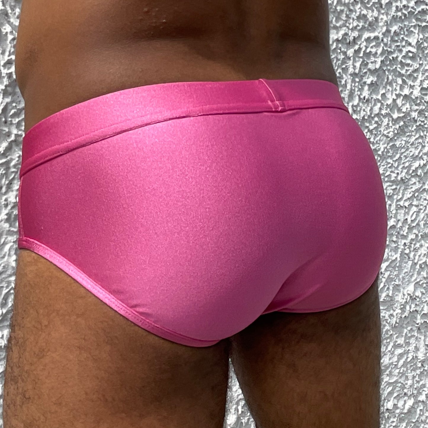 Gros plan sur le derrière d'un homme sexy mis en valeur par le maillot de bain fuschia de la marque Française Le Beau Tom. Fabrication Portugal.